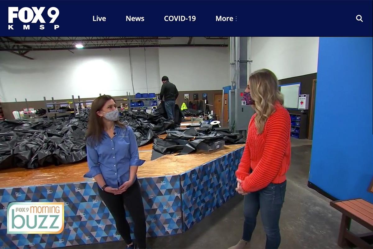 Shayne Wells of Fox9 discusses inflatables with Stephanie Meacham during her tour at Landmark Creations