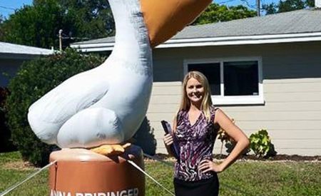 realtor standing next to Custom Inflatable Pelican