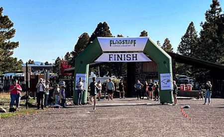Racers running through the custom inflatable arch at Flagstaff High School